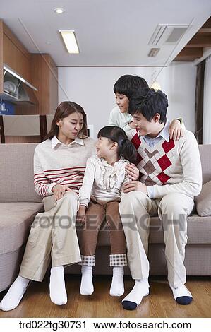 Stock Image - Happy family talking on the sofa. Fotosearch