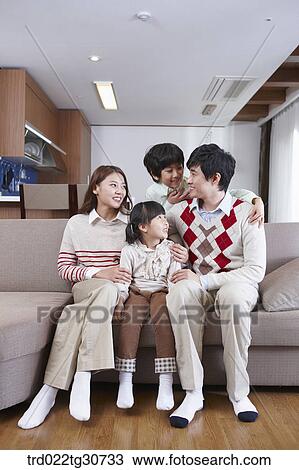 Stock Image - Happy family talking on the sofa. Fotosearch