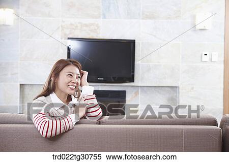 Happy woman on the sofa and television View Large Photo Image Stock Photography - Happy woman on the sofa and television. Fotosearch