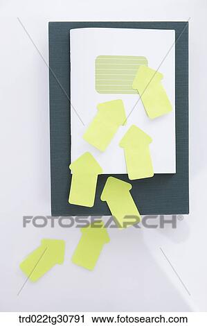 Papers and arrow shaped post its on top View Large Photo Image Stock Image - Papers and arrow shaped post its on top. Fotosearch