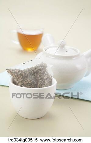 Stock Photography - Tea bag, a tea pot and a cup of tea. Fotosearch