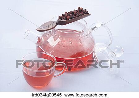 Stock Photography - Tea pot and a cup of dandelion tea and its dried flowers. Fotosearch
