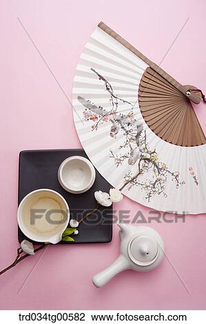 Stock Image - Tea set with a cherry blossom drawn fan. Fotosearch