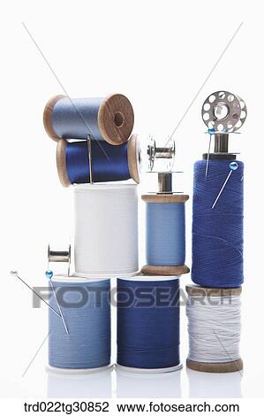 Stock Image - Various reel of threads and sewing tools in blue. Fotosearch