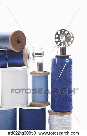 Stock Image - Various reel of threads and sewing tools in blue. Fotosearch