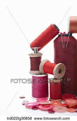 Stock Photo - Various reel of threads and sewing tools in red. Fotosearch