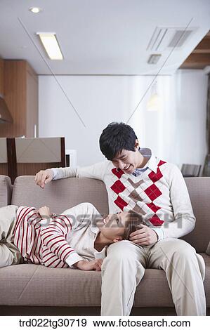 Stock Photo - Woman resting on man's lap on the sofa. Fotosearch