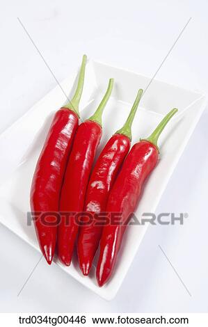 Stock Photograph - A Plate Of Four Red Peppers. Fotosearch