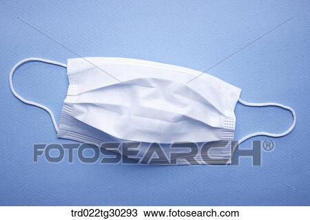 A white mask with blue background View Large Photo Image Stock Image - A white mask with blue background. Fotosearch