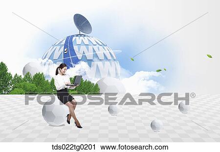 Stock Image - A woman looking at laptop with internet environment around. Fotosearch