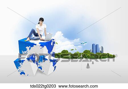 Stock Image - A woman typing laptop on the globe block. Fotosearch