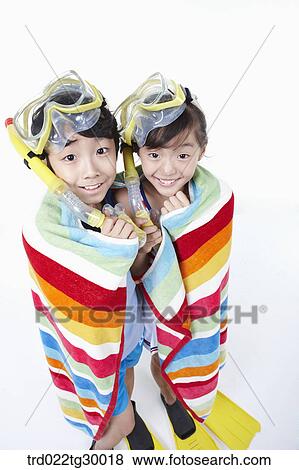 Stock Photo - boy and girl are covering themselves with a blanket. Fotosearch