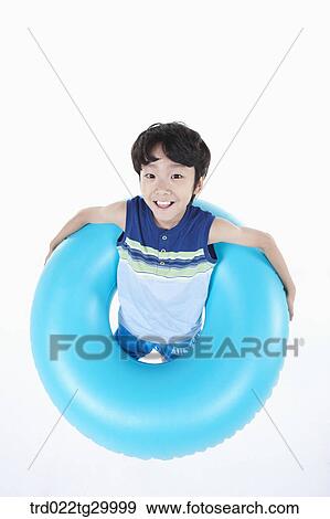 Stock Photo - boy is standing with holding beach ball. Fotosearch