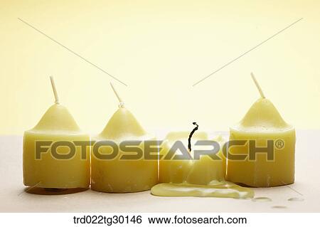 Stock Photograph - Burned yellow candle with other yellow candles in a row. Fotosearch