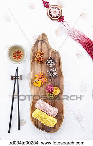 Picture - Colorful Korean dessert, a cup of tea, chopsticks, and clothes accessory . Fotosearch