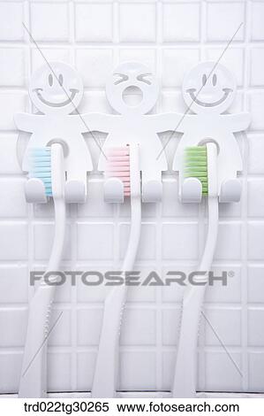 Stock Photography - Colorful tooth brush hung upto funny holders. Fotosearch