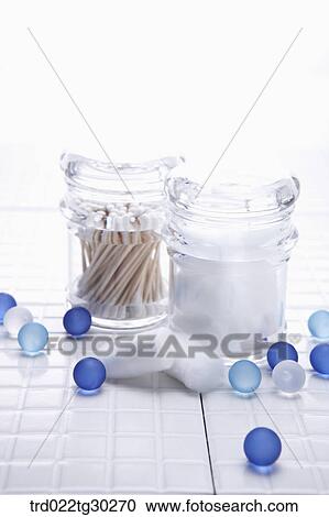 Stock Image - cotton swap and cotton in the plastic containers with blue balls around. Fotosearch