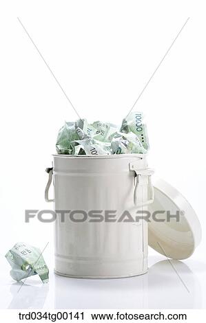 Stock Image - crumpled money bills in waste bucket. Fotosearch