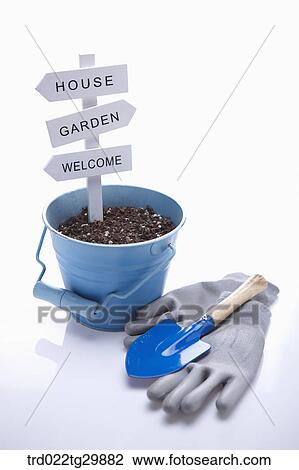 Stock Image - dirt in flower pot and gloves with shovel. Fotosearch