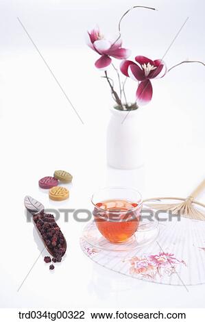 Stock Image - Dried fruit, Korean dessert, a cup of tea, a fan, and flowers. Fotosearch