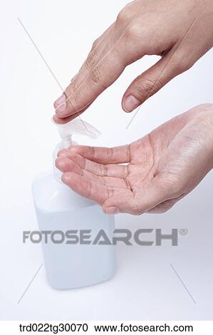 Stock Image - finger pushes pump of liquid soap. Fotosearch