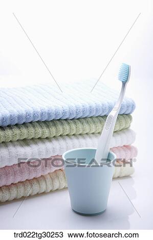 Folded colorful towels and a tooth brush in cup View Large Photo Image Stock Image - Folded colorful towels and a tooth brush in cup . Fotosearch