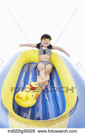 Stock Photograph - girl is sitting on boat with dolls. Fotosearch