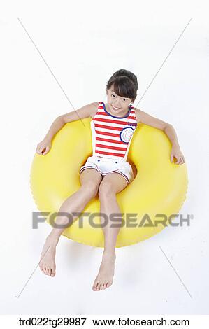 Stock Photo - girl is sitting on the tube. Fotosearch