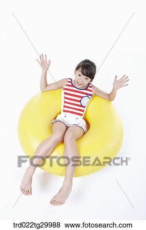 Stock Photo - girl is sitting on the tube. Fotosearch