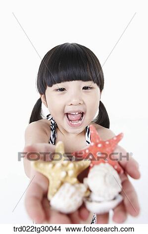 girl stretched her arms out with starfishes and shells View Large Photo Image Picture - girl stretched her arms out with starfishes and shells. Fotosearch