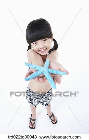 Stock Image - girl stretched her arms out with starfish. Fotosearch