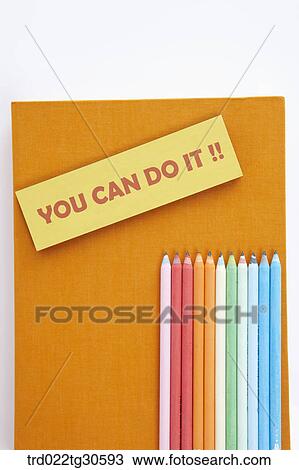 Stock Image - Orange Book With Various Colors Of Pencils. Fotosearch