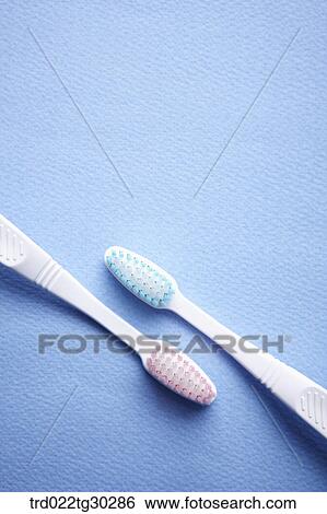 Stock Photograph - Pink and blue tooth brushes together. Fotosearch