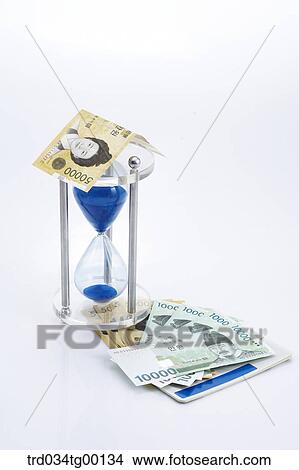 spreaded money bills and hour glass View Large Photo Image Picture - spreaded money bills and hour glass. Fotosearch