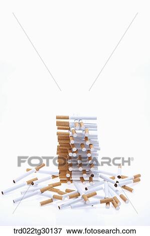 Stock Photo - Stacked cigarettes with other scatted cigarettes around. Fotosearch