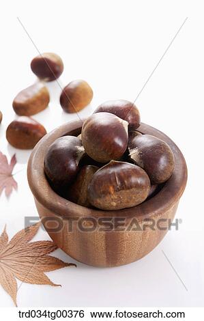 Stock Photograph - Wooden Bowl Of Chestnuts And Maple Leaves. Fotosearch