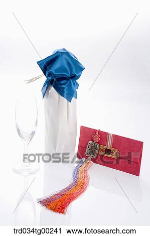 Stock Image - Wrapped bottles, a glass, and red envelope . Fotosearch