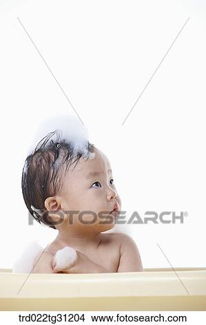 A baby taking a bath in the bathtub with the bubble on his body View Large Photo Image Picture - A baby taking a bath in the bathtub with the bubble on his body. Fotosearch