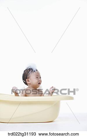 Stock Image - A baby taking a bath in the bathtub with the bubble on his body. Fotosearch