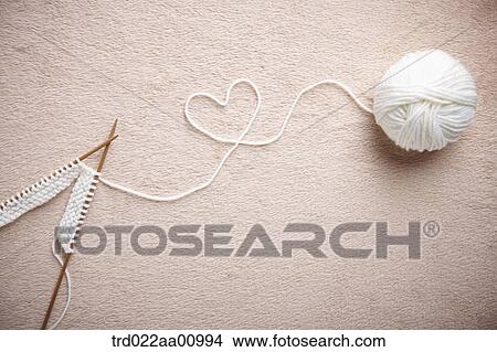 A ball of white wool and knitting needles making the heart View Large Photo Image Picture - A ball of white wool and knitting needles making the heart. Fotosearch
