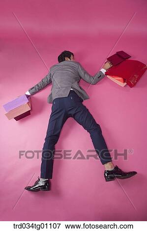 A fell down man with many shopping bags around View Large Photo Image Stock Photo - A fell down man with many shopping bags around. Fotosearch