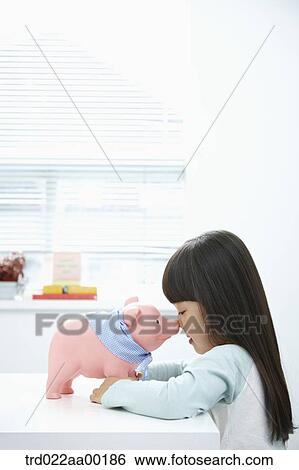 A girl facing a pink piggy bank View Large Photo Image Stock Photograph - A girl facing a pink piggy bank. Fotosearch