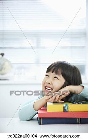 A girl having her hands on the pile of books View Large Photo Image Picture - A girl having her hands on the pile of books. Fotosearch
