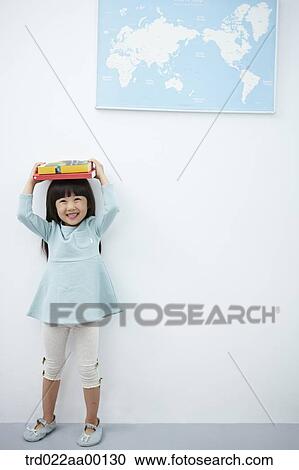 A girl holding up books over her head with the world map View Large Photo Image Stock Image - A girl holding up books over her head with the world map . Fotosearch