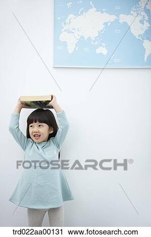 A girl holding up books over her head with the world map View Large Photo Image Stock Image - A girl holding up books over her head with the world map . Fotosearch