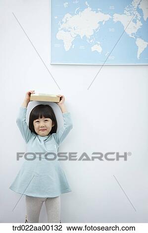 A girl holding up books over her head with the world map View Large Photo Image Stock Image - A girl holding up books over her head with the world map . Fotosearch