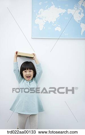 A girl holding up books over her head with the world map View Large Photo Image Stock Image - A girl holding up books over her head with the world map . Fotosearch