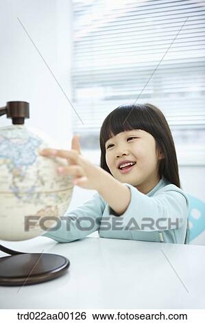 A girl looking a globe with her hand on it View Large Photo Image Stock Photograph - A girl looking a globe with her hand on it. Fotosearch