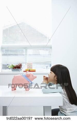 A girl looking at a pink piggy bank View Large Photo Image Stock Photo - A girl looking at a pink piggy bank. Fotosearch