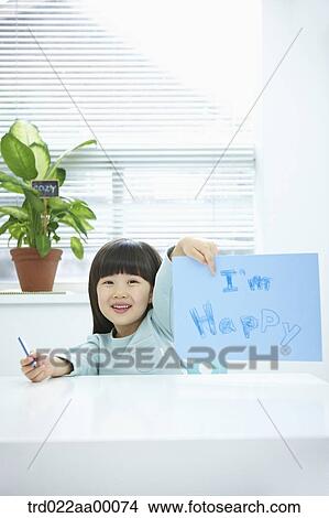 A girl showing blue paper with 'I'm happy' with a pencil in her hand View Large Photo Image Picture - A girl showing blue paper with 'I'm happy' with a pencil in her hand. Fotosearch